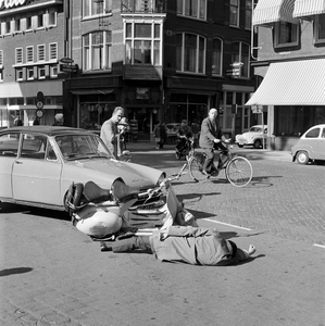 125729 Afbeelding van een (geënsceneerd) ongeluk tussen een auto en een scooter op de hoek van de Ganzenmarkt en de ...